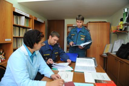 Сотрудники МЧС проводят проверку пожарной безопасности в столичных школах и детских садах перед началом учебного года. На снимке: проверка документации.