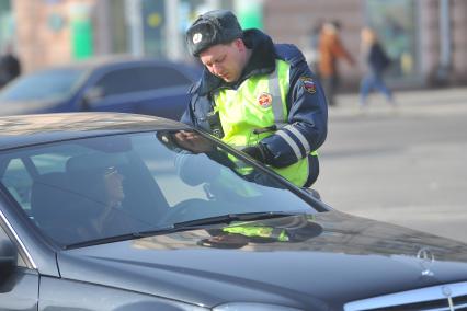 Проверка документов. На снимке: сотрудник ДПС и водитель.