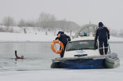 На реке Обь, в Барнауле проходят учения МЧС по спасению рыбаков. На снимке: спасатели вытаскивают из ледяной воды рыбака с спасательного судна МЧС на воздушной подушке `Марс 700`.