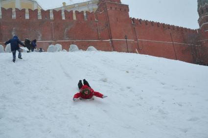 Прогулка в Александровском саду. На снимке: дети катаются с горки у Кремлевской стены.