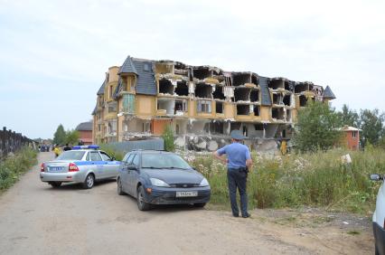 Снос незаконно построенного многоквартирного дома в  поселке Вешки. Суд обязал собственника незаконно возведенного дома Виктора Холода снести его за счет собственных средств, однако требование суда он не выполнил. Судебные приставы управления ФССП по Московской области, выполняя решение суда, начали демонтаж здания. На снимке: полицейский.