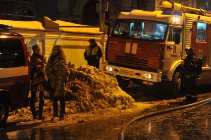 Во время тушения пожара в здании Государственного института театрального искусства (ГИТИС). На снимке: студентки ГИТИСа и пожарные.