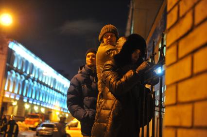 Во время тушения пожара в здании Государственного института театрального искусства (ГИТИС). На снимке: люди наблюдают за работой пожарных из-за забора ГИТИСа.