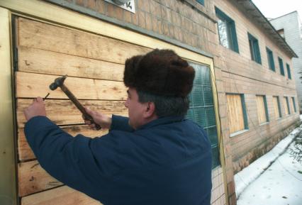 Последствия аварии на Чернобыльской АЭС. На снимке: мужчина заколачивает дом в Чернобыле.