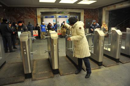 Московский метрополитен На снимке: пассажиры проходят в метро через турникет