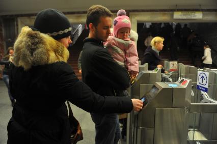 Московский метрополитен На снимке: пассажиры проходят в метро через турникет