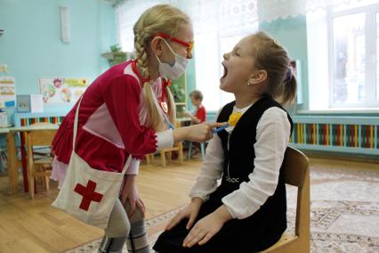 Дети в детском саду играют в больницу.