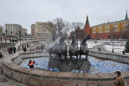 Манежная площадь. На снимке: сотрудник коммунальной службы города моет скульптурную группу `Времена года` фонтана \"Гейзер`.