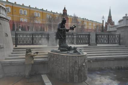 Манежная площадь. На снимке: сотрудник коммунальной службы города моет скульптуру по мотивам сказки `О рыбаке и рыбке`.