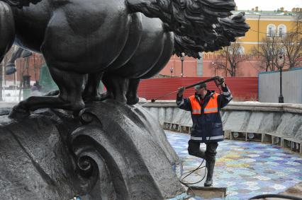 Манежная площадь. На снимке: сотрудник коммунальной службы города моет скульптурную группу `Времена года` фонтана \"Гейзер`.