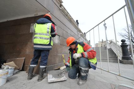 Манежная площадь. На снимке: сотрудники коммунальных служб города ремонтируют фасад здания ТЦ `Охотный Ряд`.