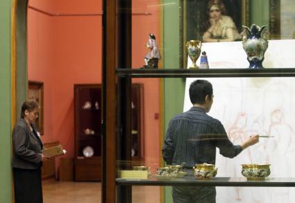 Юноша рисует картину на практических занятиях в выставочных залах Национального художественного музея Беларуси.