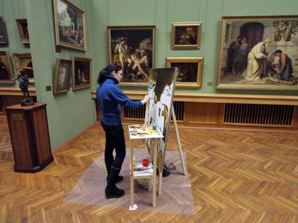Девушка рисует картину на практических занятиях в выставочном зале Национального художественного музея Беларуси.