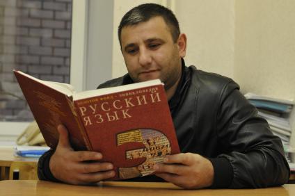 Государственное тестирование по русскому языку. На снимке: мужчина держит в руках энциклопедию по русскому языку.