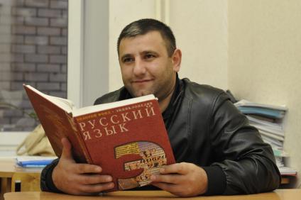 Государственное тестирование по русскому языку. На снимке: мужчина держит в руках энциклопедию по русскому языку.