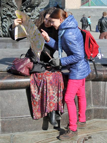 Две девушки изучают карту Москвы.