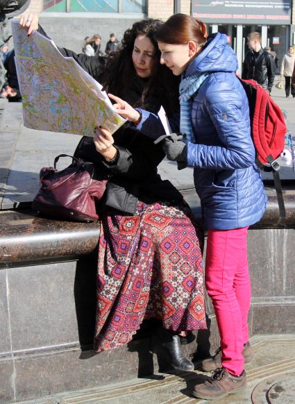 Две девушки изучают карту Москвы.