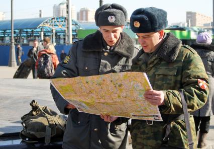 Двое военнослужащих изучают карту Москвы.
