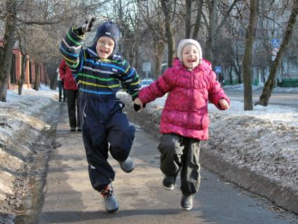 Двое детей гуляют по улице.