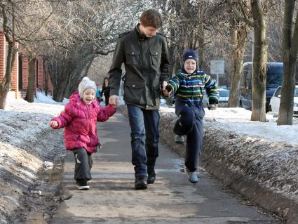 Двое детей гуляют по улице.