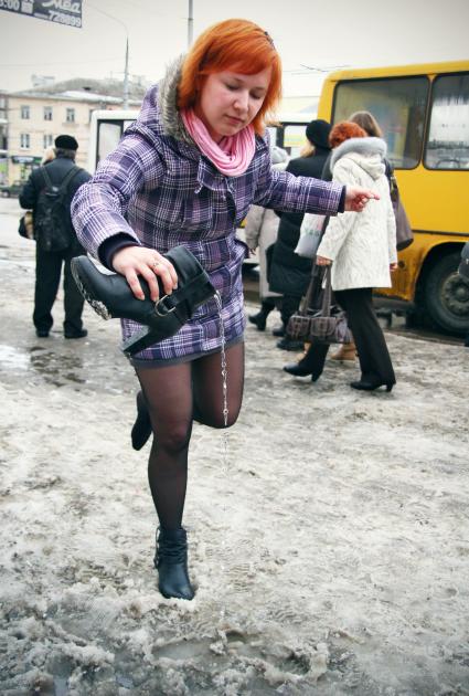 Девушка выливает из сапога воду.