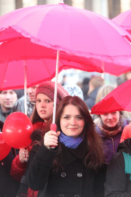 Акция в Санкт-Петербурге `Сердце города 2012` На снимке: девушка стоит под красным зонтом.