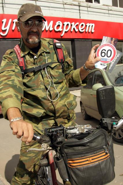 Флеш-моб за соблюдение правил дорожного движения ПДД в Самаре. На снимке: мужчина на велосипеде с наклейкой в виде знака ограничения скоростного режима в городе.