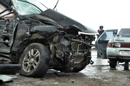 Покореженный автомобиль на загородной трассе.