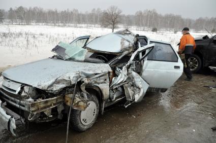 Покореженный автомобиль на загородной трассе.