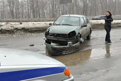 Покореженный автомобиль на загородной трассе.