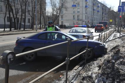 2-я Хуторская улица. Автомобиль врезался в ограждение тротуара. На снимке: сотрудник ДПС на месте ДТП.