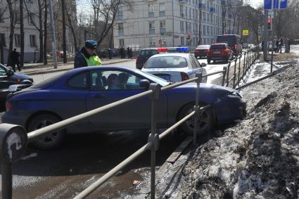 2-я Хуторская улица. Автомобиль врезался в ограждение тротуара. На снимке: сотрудник ДПС на месте ДТП.