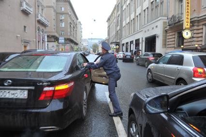 `Дагестанская свадьба в центре Москвы: разгоряченные джигиты стреляли в воздух и другие машины`. На снимке: одна из гостей свадьбы, игнорируя полицейского, скрывается.