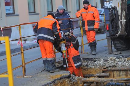 Ремонт дорожного покрытия. На снимке: рабочие с отбойным молотком.