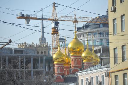 Строительный кран и купола храма.