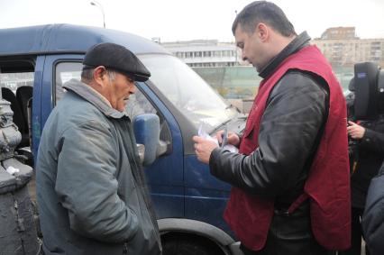 Сотрудники Госавтоинспекции совместно с ФМС провели рейд по выявлению незаконных маршрутных такси. На снимке: сотрудник ФМС и водитель маршрутногшо такси.