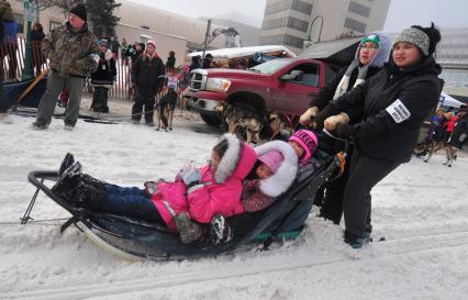 Аляска. Ежегодные гонки на собачьих упряжках (Iditarod Trail Sled Dog Race). На снимке: дети на нартах.