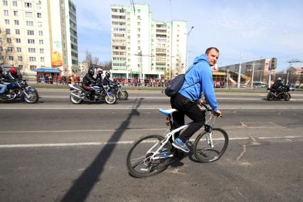 Мужчина на велосипеде едет вместе с колонной байкеров по улице Притыцкого в Минске.