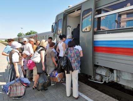 Пассажиры совершают посадку в поезд.