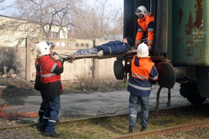 Комплексные учения МЧС на старом ж/д вокзале в Ульяновске. На снимке: спасатели достают из вагона поезда пострадавшего на носилках.