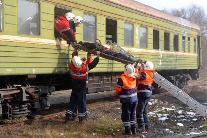 Комплексные учения МЧС на старом ж/д вокзале в Ульяновске. На снимке: спасатели достают пострадавшего на носилках из вагона поезда через окно.