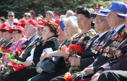 Ветераны сидят на концерте с цветами