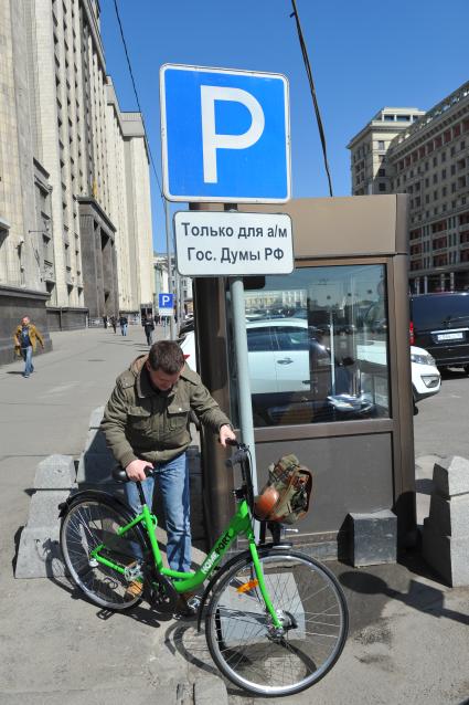 В центре Москвы на Бульварном кольце оборудуют 11 станций велопроката. Работать они будут автоматически. Велосипед можно будет взять в одном месте, а сдать в другом. На снимке: велосипедист у  дорожного знака `Место для стоянки`.