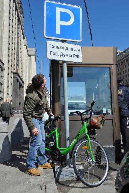 В центре Москвы на Бульварном кольце оборудуют 11 станций велопроката. Работать они будут автоматически. Велосипед можно будет взять в одном месте, а сдать в другом. На снимке: велосипедист у  дорожного знака `Место для стоянки`.