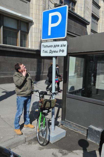 В центре Москвы на Бульварном кольце оборудуют 11 станций велопроката. Работать они будут автоматически. Велосипед можно будет взять в одном месте, а сдать в другом. На снимке: велосипедист у  дорожного знака `Место для стоянки`.