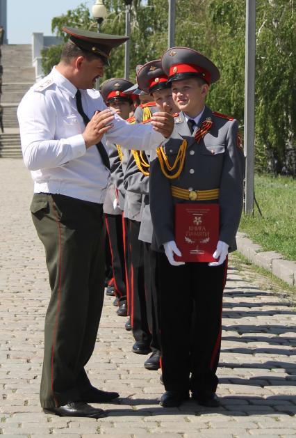 Кадеты держат в руках книгу памяти и слушают своего командира