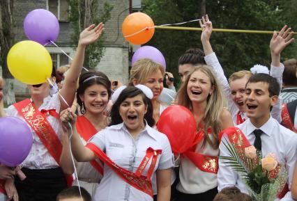 Школьники держат в руках воздушные шары