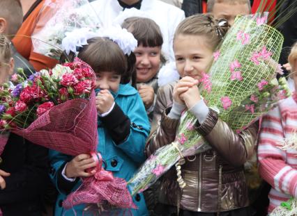 Две школьницы держат в руках букеты цветов
