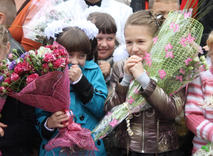 Две школьницы держат в руках букеты цветов