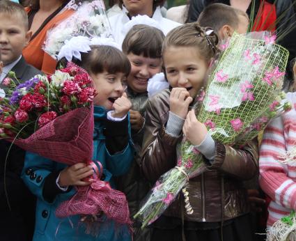 Две школьницы держат в руках букеты цветов